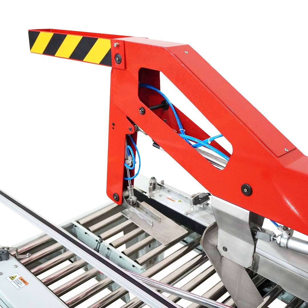 Seladora SXJ-6050AC — detalhe do braço pneumático de fechamento das abas superiores